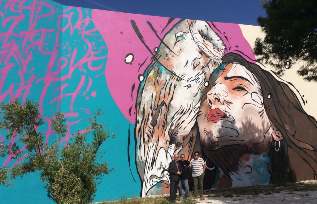 Η τοιχογραφία στο 1ο ΕΠΑΛ Ραφήνας, που φιλοτεχνήθηκε από την UrbanAct. Στο στιγμιότυπο, οι Γιάννης Ρούντος, διευθυντής Εταιρικών Σχέσεων και Υπευθυνότητας INTERAMERICAN, ο Κυριάκος Ιωσηφίδης (UrbanAct) και ο Γεράσιμος Καβαλλιεράτος, διευθυντής του ΕΠΑΛ