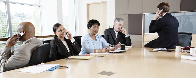 Five executives using cell phones in boardroom