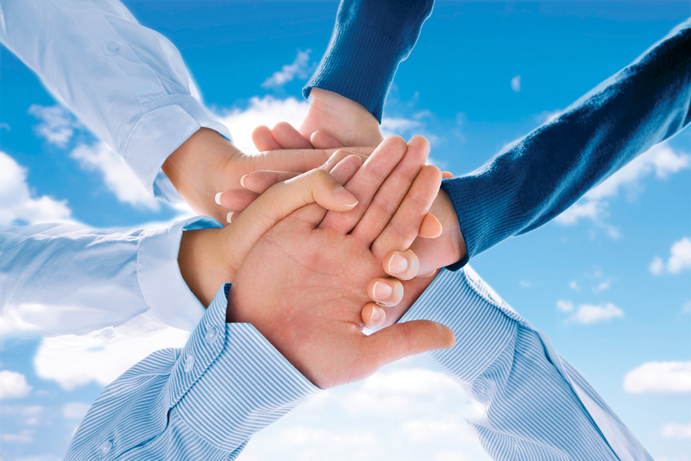 Close up view of hands getting together  on blue background