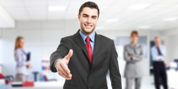 Portrait of an handsome businessman giving an handshake