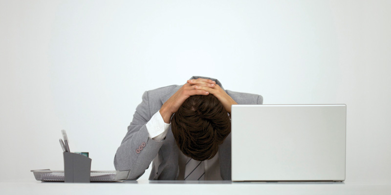 Businessman sitting at desk with head down