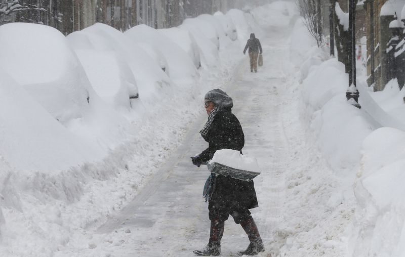 A woman shovels snow on Joy Street during a winter blizzard in Boston, Massachusetts in this February 15, 2015, file photo. REUTERS/Brian Snyder/Files