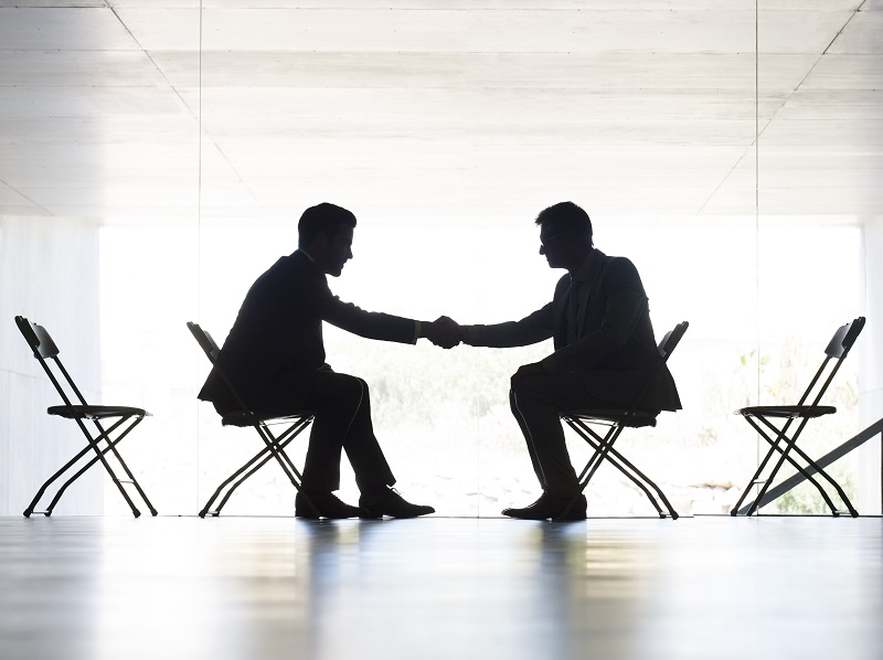 Businessmen shaking hands in office