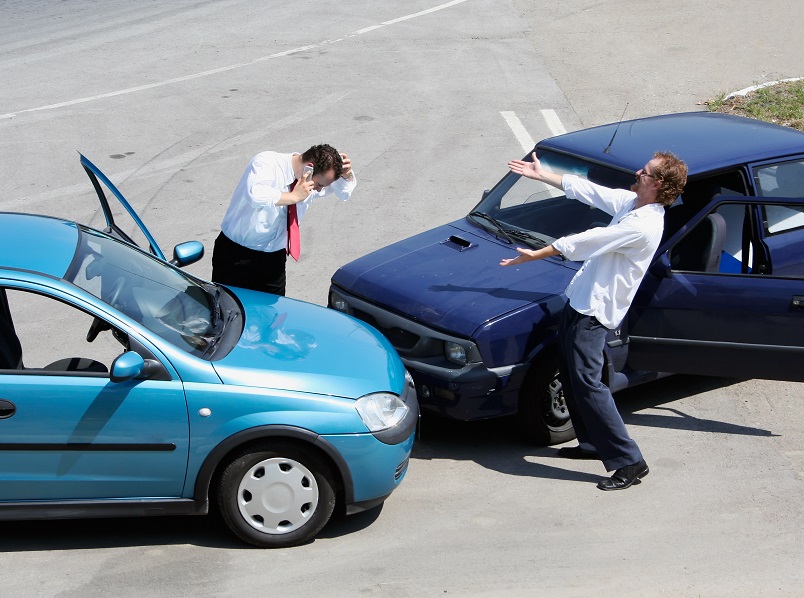 Traffic accident - one driver on the mobile phone, second expressing anger