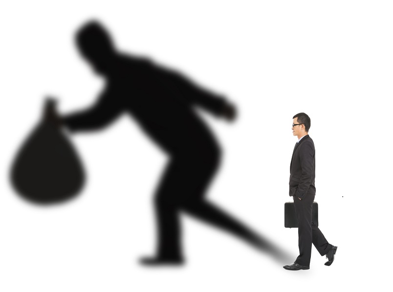 businessman walking and holding bag with thief shadow