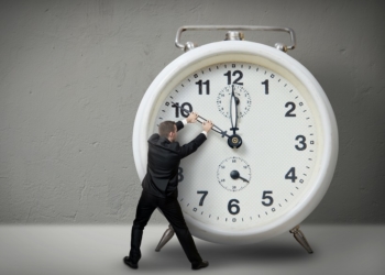 Businessman pulling a clock hand backwards,time
