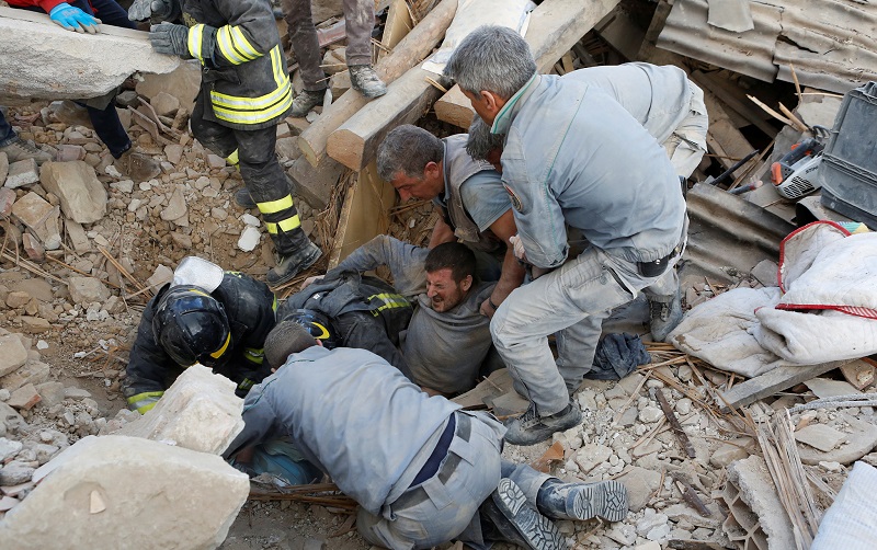 A man is rescued alive from the ruins following an earthquake in Amatrice, central Italy, August 24, 2016. REUTERS/Remo Casilli TPX IMAGES OF THE DAY - RTX2MSE4