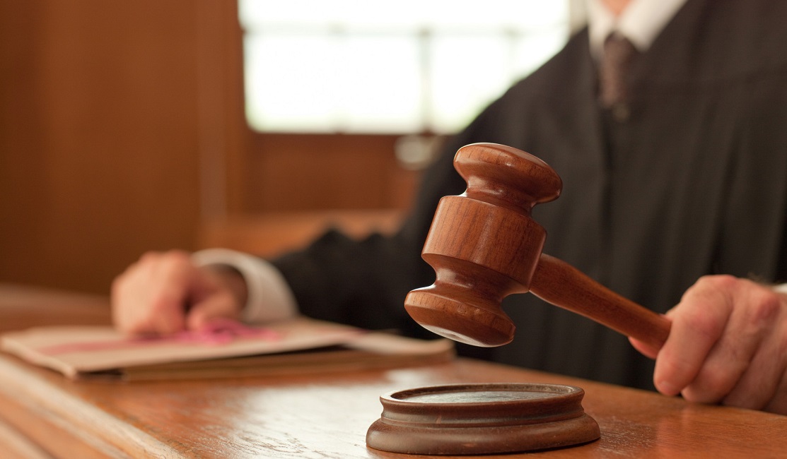 Judge holding gavel in courtroom