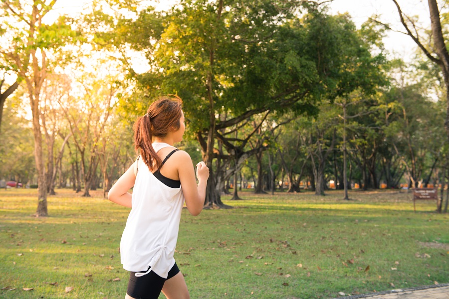 Young woman running in wood, training and exercising for trail run marathon endurance in morning sunrise. Fitness healthy lifestyle concept. Vintage effect style pictures.