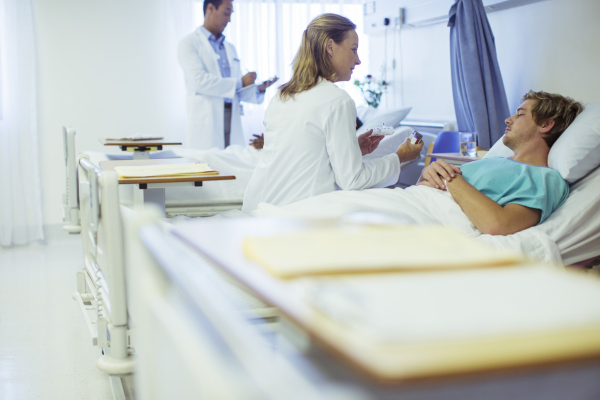 Doctor talking to patient in hospital bed