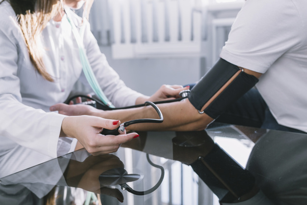crop-woman-measuring-pulse-to-patient_23-2147763809