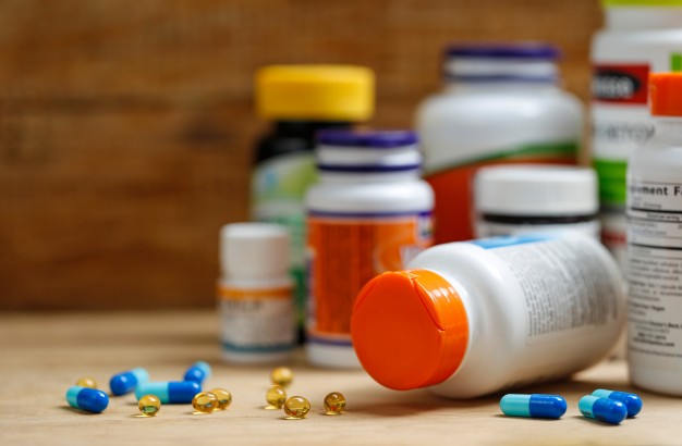 medicine-bottles-and-tablets-on-wooden-desk_1387-420