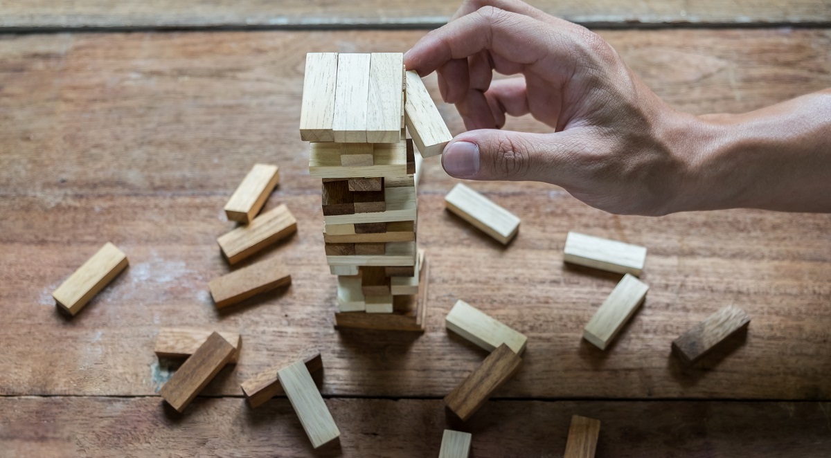 Planning, risk and strategy in business, businessman and engineer gambling placing wooden block on a tower.