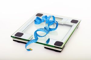 blue-tape-measuring-on-clear-glass-square-weighing-scale