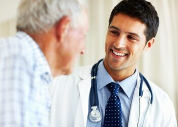 Elderly man receiving advice from male doctor