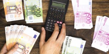 flat-lay-man-counting-money-with-calculator