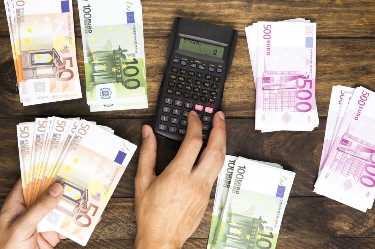 flat-lay-man-counting-money-with-calculator
