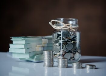 Bottles of cash with coins in saving money concept