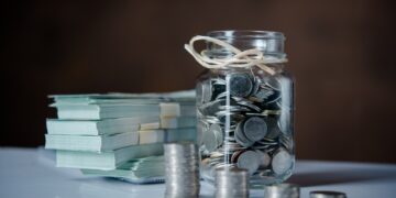 Bottles of cash with coins in saving money concept