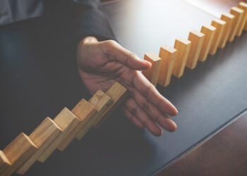 problem-solving-close-up-view-hand-business-woman-stopping-falling-blocks-table-concept-about-taking-responsibility
