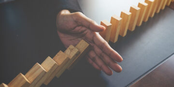 problem-solving-close-up-view-hand-business-woman-stopping-falling-blocks-table-concept-about-taking-responsibility