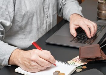 businessman-accountant-holding-pen-working-desk-using-laptop-calculate-financial-report