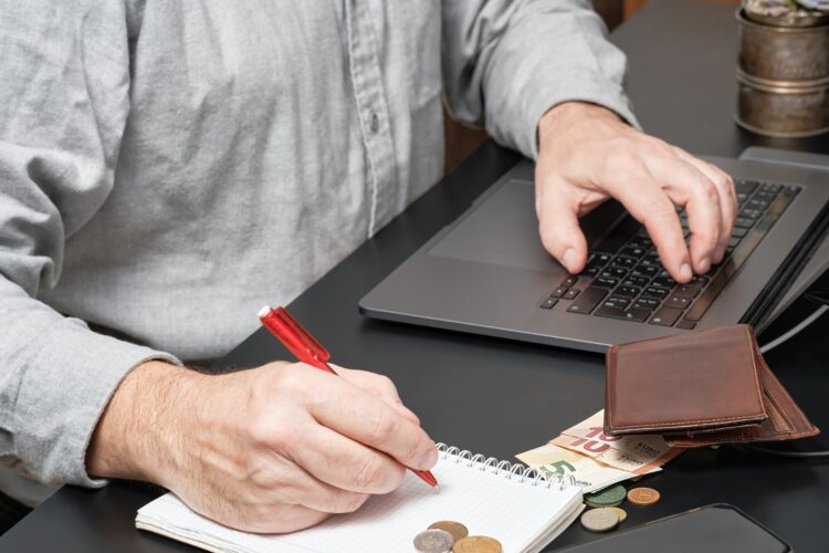 businessman-accountant-holding-pen-working-desk-using-laptop-calculate-financial-report