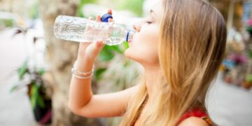 tired-female-tourist-drinking-water-outdoors