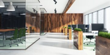 Natural style open space office interior with loft windows, a wooden floor, an aquarium like conference room area and rows of computer desks. 3d rendering