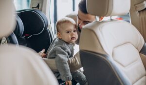Father with baby daughter in a car showroom