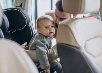 Father with baby daughter in a car showroom