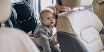 Father with baby daughter in a car showroom