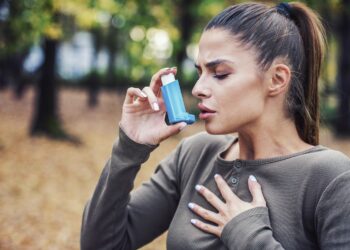 Woman using asthma inhaler