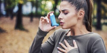 Woman using asthma inhaler