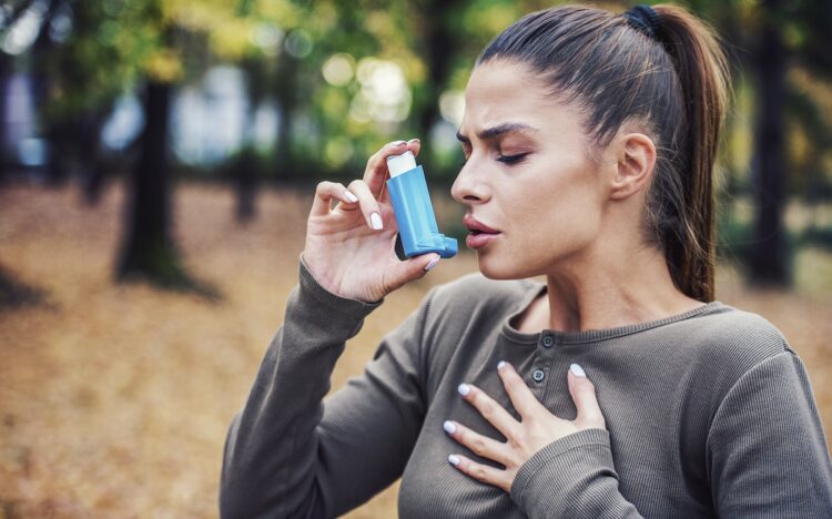 Woman using asthma inhaler