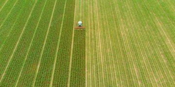 aerial-tractor-working-cultivated-fields-farmland-agriculture-occupation-top-down-view-lush-green-cereal-crops-sprintime-italy_107467-363