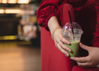 closeup-green-drink-ice-matcha-latte-blurred-background-cafe