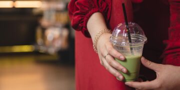 closeup-green-drink-ice-matcha-latte-blurred-background-cafe