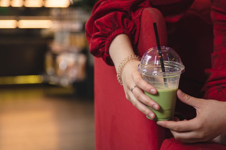 closeup-green-drink-ice-matcha-latte-blurred-background-cafe
