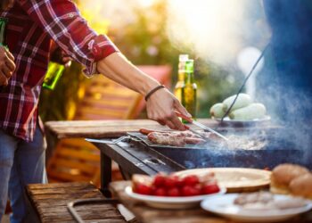 young-men-roasting-barbecue-grill-cottage-countryside