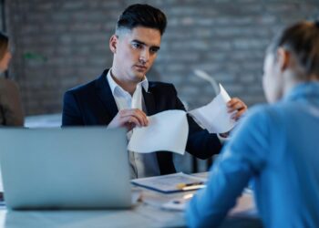 bossy-manager-tearing-apart-business-reports-front-his-female-colleague-office