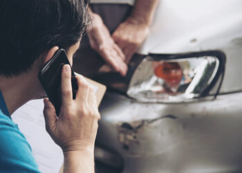 Insurance agent working during on site car accident claim process - people and car insurance claim concept