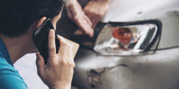 Insurance agent working during on site car accident claim process - people and car insurance claim concept