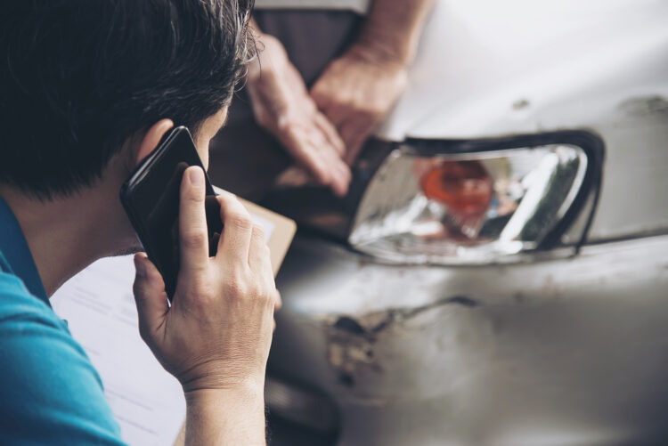 Insurance agent working during on site car accident claim process - people and car insurance claim concept