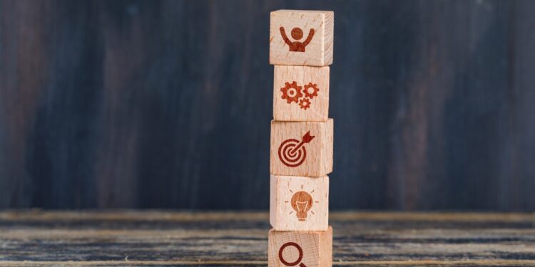 business-strategy-concept-with-wooden-cubes-wooden-grunge-background-side-view