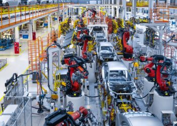 Assembly line production of new car. Automated welding of car body on production line. robotic arm on car production line is working