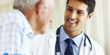 Portrait of handsome doctor talking with senior patient