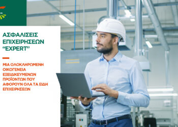 Chief Engineer in the Hard Hat Walks Through Light Modern Factory While Holding Laptop. Successful, Handsome Man in Modern Industrial Environment.